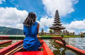 Lady in blue dress looking at temple in Bali 